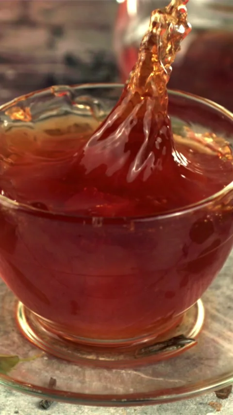Super slow motion in a cup of tea drops a piece of sugar with splashes. Filmed Stock Footage 335286095
