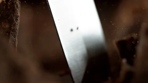 Super slow motion of cutting off dark chocolate pieces by chisel Stock Footage 140744124