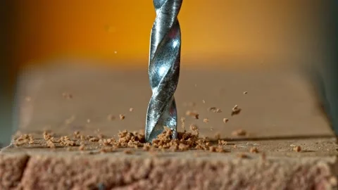 Super slow motion of detail of a drill bit drilling into brick wall. Stock Footage 199702823