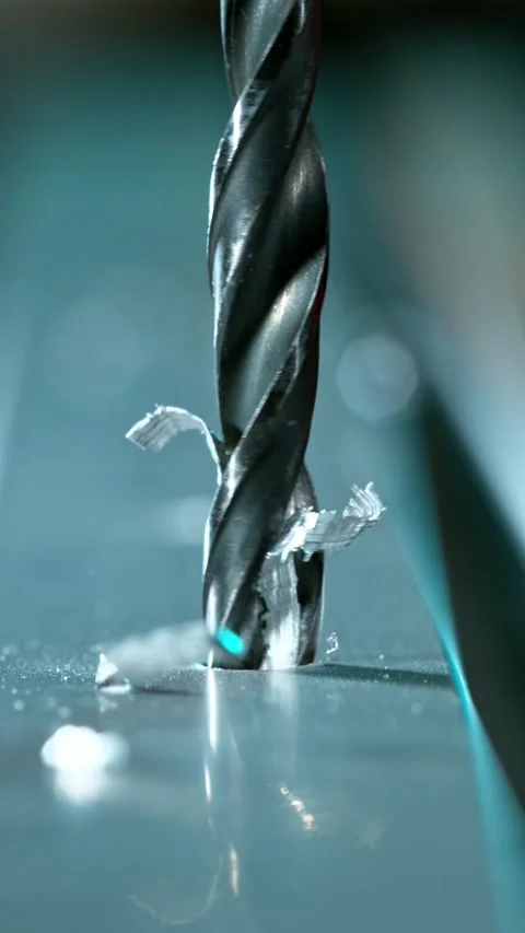 Super slow motion of detail of a drill bit drilling into aluminium pipe. Stock Footage 308371244