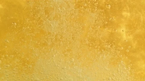 Super Slow Motion Detail Shot of Sparkling White Wine Bubbles on Golden Luxury Stock Footage