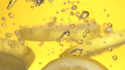 Super Slow Motion Dramatic Slowmotion Of Lemon Segment Entering Fizzy Yellow Stock Footage 327095858