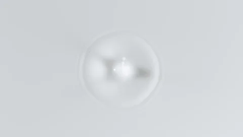 Super slow motion of dripping milk drop filmed with macro lens. Top view Stock Footage 99445330