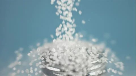 Super slow motion drop salt on a salt shaker on blue . Filmed on a high-speed Stock Footage 148559512