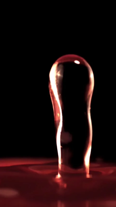 Super slow motion drop of wine falls with splashes into the glass. Filmed on a Stock Footage 335287256