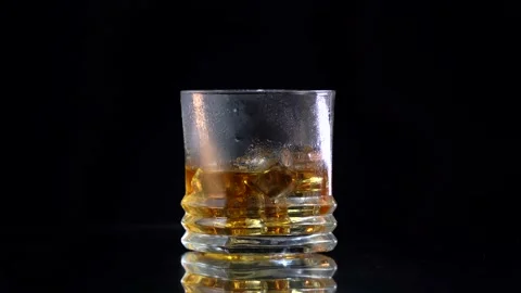 Super slow motion of droping the ice into the whiskey. Stock Footage 153351353