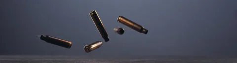 SUPER SLOW MOTION Empty machine gun shells falling on a ground against blue bg Stock Footage 152615951