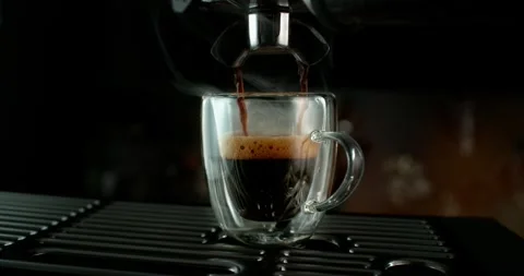 Super slow motion of espresso pouring from a coffee machine into a glass cup Stockbeeldmateriaal 331145474