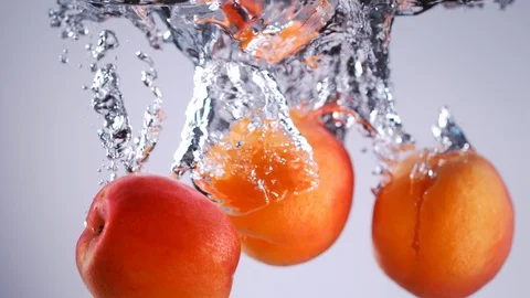 Super slow motion of falling apricots into water. Stock Footage 90668893