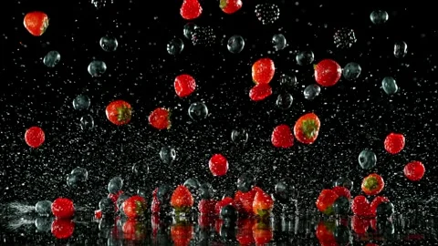 Super Slow Motion of Falling Berries into Water on Black Background. Stock Footage 251313550
