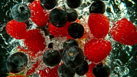 Super Slow Motion of Falling Berries Into Water on Black Background. Stock Footage 256215359