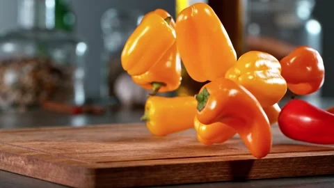Super slow motion of falling chilli peppers on wooden board. Stock Footage 166968480