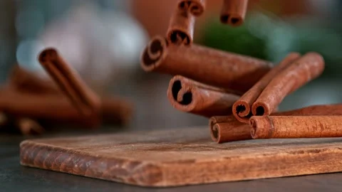 Super slow motion of falling cinnamon spice on wooden board. Stock Footage 166966558