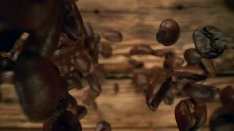 Super slow motion of falling coffee beans on wooden background. Stock Footage 149035901