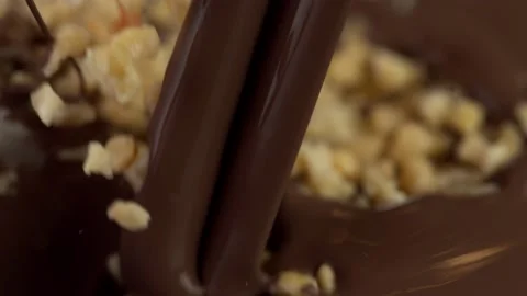 Super slow motion of falling crushed nuts into dark hot chocolate. Stock Footage 141062764