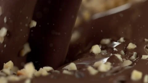 Super slow motion of falling crushed nuts into dark hot chocolate. 141073176