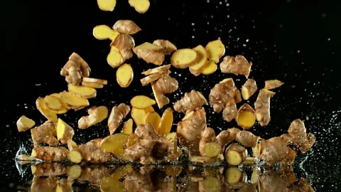 Super Slow Motion of Falling Ginger Pieces into Water. Stock Footage 251660635