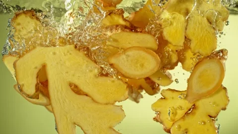 Super Slow Motion of Falling Ginger Pieces into Water. Stock Footage 263875480