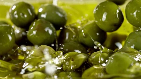 Super slow motion of falling green olives into oil. Stock Footage 195339471