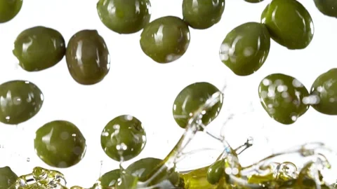 Super slow motion of falling green olives into oil. Stock Footage 195339681