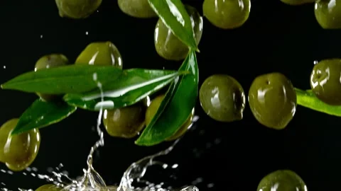 Super slow motion of falling green olives into oil. Stock Footage 195339797
