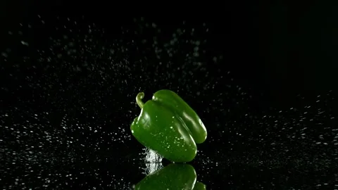 Super Slow Motion of Falling Green Pepper into Water on Black Background. Stock Footage 251660874