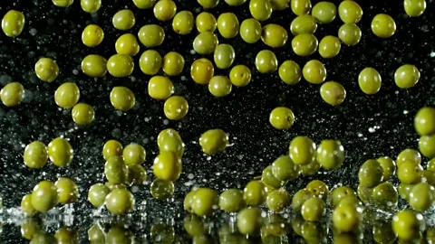 Super Slow Motion of Falling Green Olives on Black Background. Stock Footage 251806460
