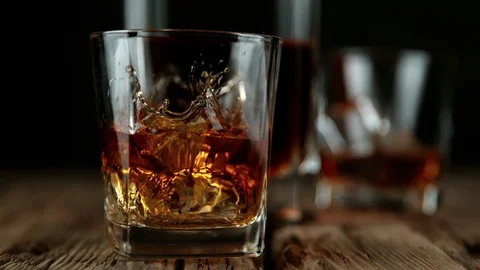 Super slow motion of falling ice cube into whiskey drink Stock Footage 121174862