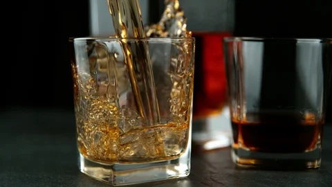 Super slow motion of falling ice cube into whiskey drink Stock Footage 121175926