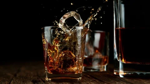 Super slow motion of falling ice cube into whiskey drink Stock Footage 122245645