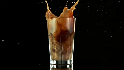 Super slow motion of falling ice cube into ice coffee drink Stock Footage 129599171