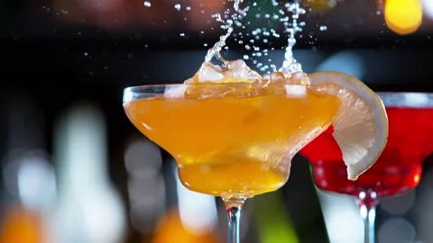 Super slow motion of falling ice cube into cocktail drink, camera movement. Stock Footage 146848049