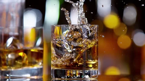 Super slow motion of falling ice cube into whiskey drink Stock Footage 157561019