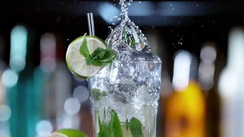 Super slow motion of falling ice cube into mojito drink, camera movement Stock Footage 157561100