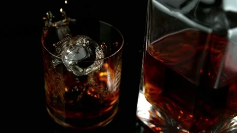 Super slow motion of falling ice cube into whiskey drink, camera motion Stock Footage 157674169
