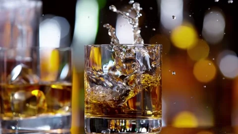 Super slow motion of falling ice cube into whiskey drink, camera motion Stock Footage 162539851
