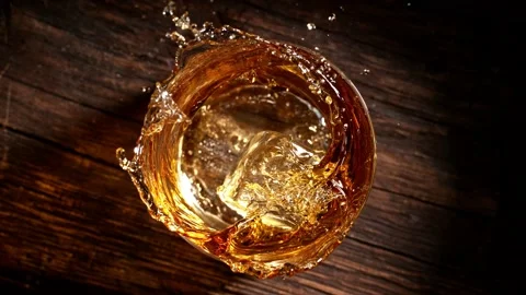 Super slow motion of falling ice cube into whiskey. Stock Footage 164956025