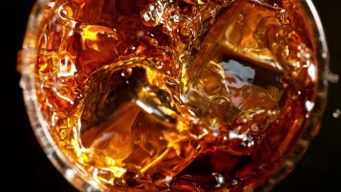Super slow motion of falling ice cube into whiskey. Stock Footage 165016344