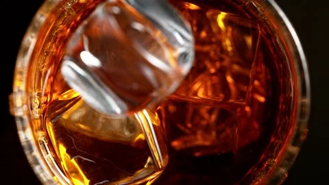 Super slow motion of falling ice cube into whiskey. Stock Footage 165018654