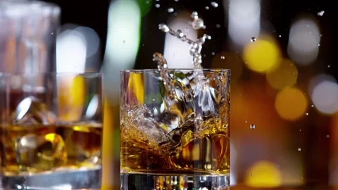 Super slow motion of falling ice cube into whiskey drink Stock Footage 206458347