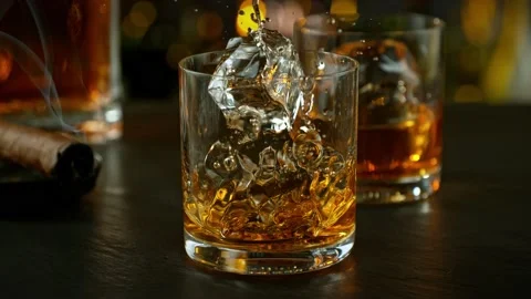 Super slow motion of falling ice cube into whisky with speed motion. Stock Footage 233066770