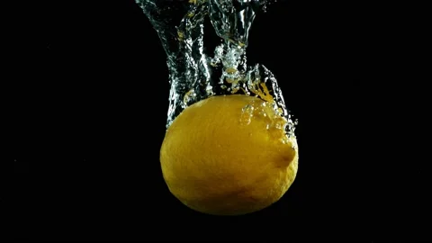 Super slow motion of falling lemon into splashing water Stock Footage 212007971