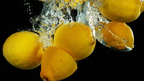 Super slow motion of falling lemon slices into splashing water Stock Footage 212008846