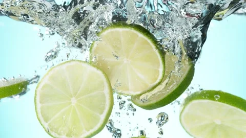 Super slow motion of falling lime slices into splashing water Stock Footage 155783543
