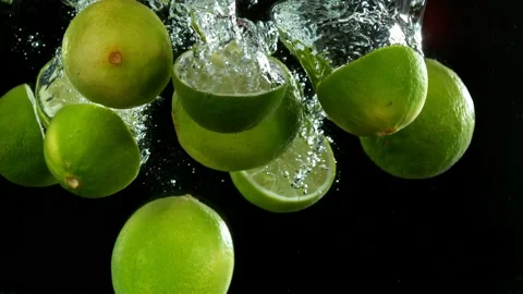 Super slow motion of falling lime slices into splashing water Stock Footage 212010806