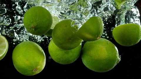 Super slow motion of falling lime slices into splashing water Stock Footage 212011298