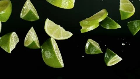 Super slow motion of falling lime slices on black background. Stock Footage 237005061