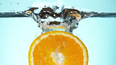 Super slow motion of falling orange slices into splashing water Stock Footage 155784190