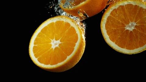 Super slow motion of falling orange slices into water. Stock Footage 212008599