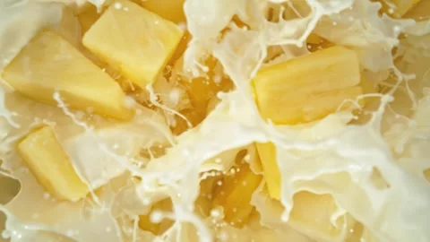 Super Slow Motion of Falling Pineapple Pieces into Cream Stock Footage 275347125